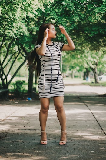 Photo of Standing Woman in White and Black Striped Mini Dress Looking Away