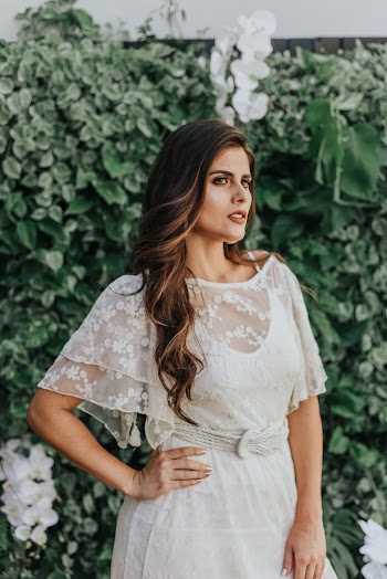 Photo of Standing Woman in White Dress with Her Right Arm Akimbo