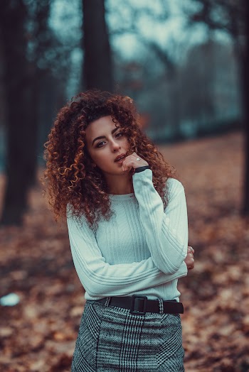 Photo of Standing Woman in White Top and Gray and Black Plaid Skirt Posing