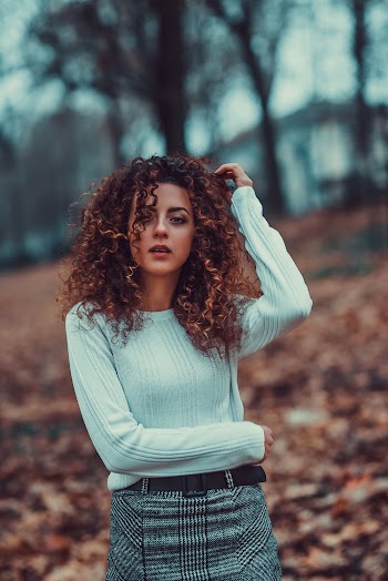 Photo of Standing Woman in White Top and Gray and Black Plaid Skirt Posing
