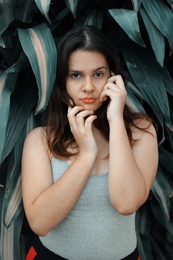 Photo of Standing Woman Posing in Front Green-leafed Plants