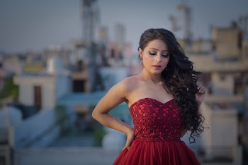 Photo of Standing Woman With Her Eyes Closed in Red Sweetheart Neckline Dress Posing