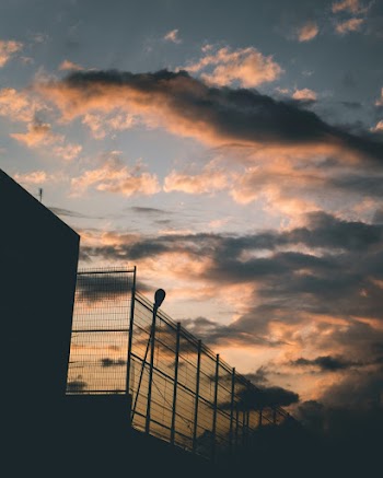Photo of Steel Fence Under Gloomy Cloudy Sky