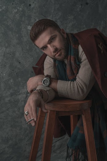 Photo of Stylish Man Leaning on Stool While Smoking