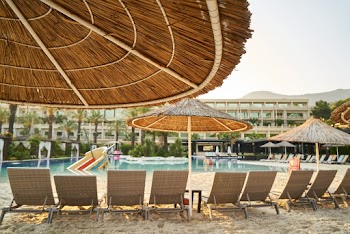 Photo of Sunloungers on Sand Near Swimming Pool