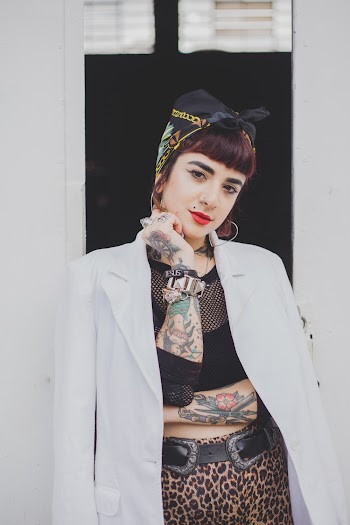 Photo of Tattooed Woman in White Suit Jacket Posing