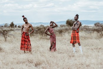Photo of Three People Wearing Red Tribal Clothes