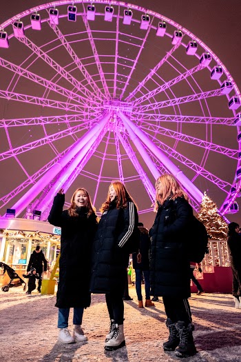 Photo of Three Women Standing Against Ferris Wheel