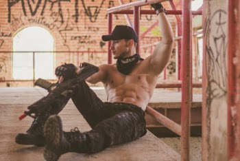 Photo of Topless Man Holding Rifle