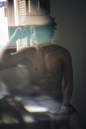 Photo of Topless Man Leaning Near Window