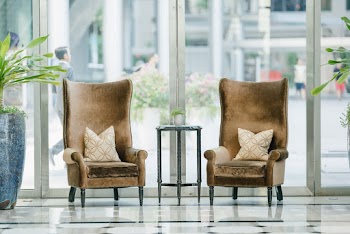 Photo of two brown sofa chairs near glass window