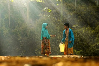 Photo of Two Children  Standing beside Green Vegetation