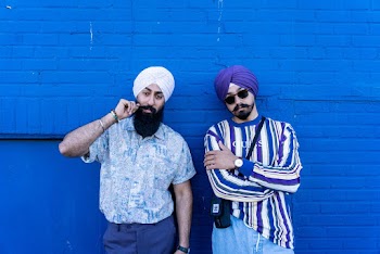 Photo of Two Indian Man in Turbans Posing In Front of Blue Wall