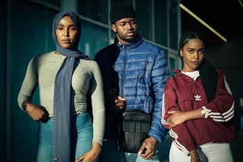 Photo of Two Muslim Women in Hijabs and a Man in a Beanie Hat Posing