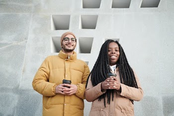 Photo of Two People Holding a Disposable Cup