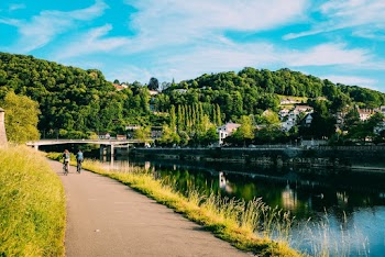 Photo of Two People Riding Bike on Paved Pathway