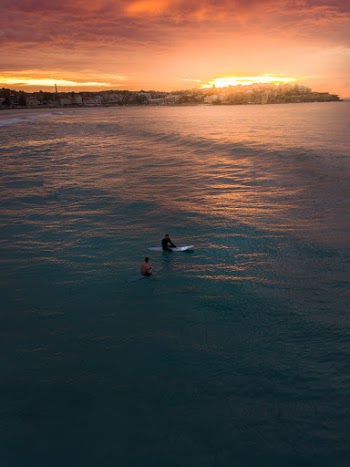Photo of Two People Surfing in Bondi Beach