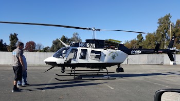 Photo of Two Person Standing in Front of White and Black Helicopter