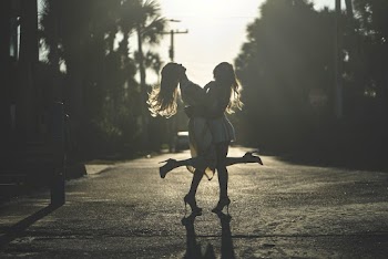 Photo of Two Women Hugging Each Other on Road