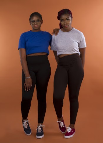 Photo of Two Women in Leggings and T-shirts Posing In Front of Orange Background