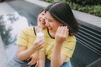 Photo of Two Women in Yellow and Black Striped Crew-neck T-shirts