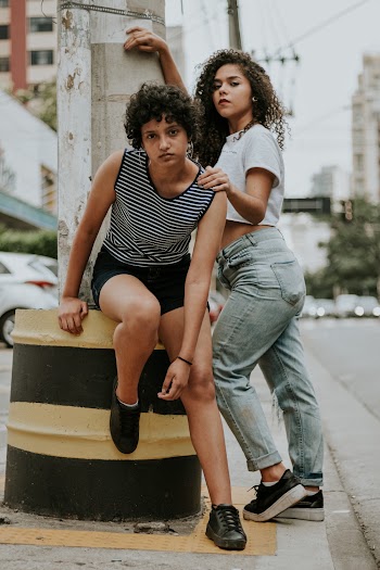 Photo of Two Women Posing on Sidewalk