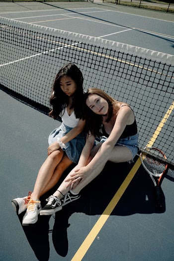 Photo Of Two Women Sitting on Tennis Court