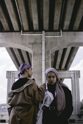 Photo of Two Women Standing Next To Each Other