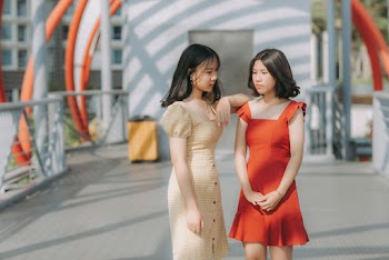Photo of Two Women Standing Together Posing