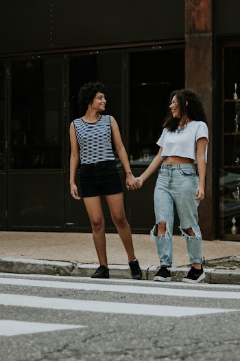 Photo of Two Women Walking on Pedestrian Crossing