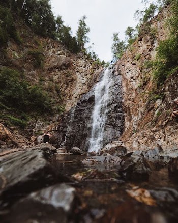 photo of waterfalls under clear blue sky during daytime