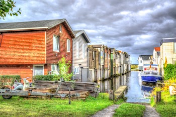 Photo of White and Blue Speedboat Beside Houses