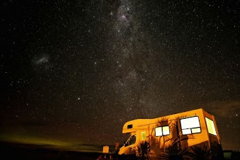 photo of white and brown vehicle during night time with stars