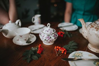 photo of white floral tea set on brown wooden table