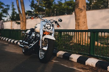 Photo of White Harley Davidson Fatboy Cruiser Motorcycle Parked by Curb