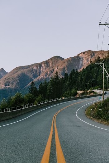 photo of winding road near mountain