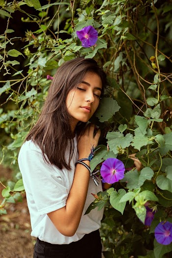 Photo of With Her Eyes Closed Woman Leaning on Flower