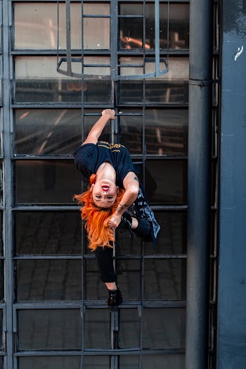 Photo of Woman Bending While Climbing on Ladder