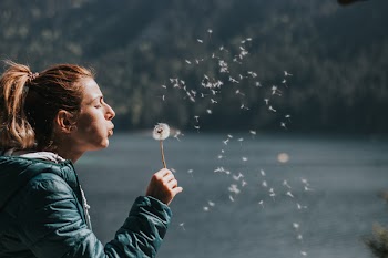 Photo of Woman Blowing Dandelion