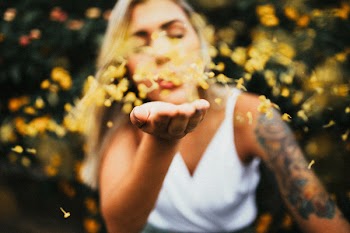 Photo of Woman Blowing Yellow Petals