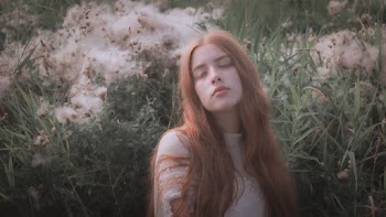 Photo of Woman Closing Her Eyes Near Green Grass