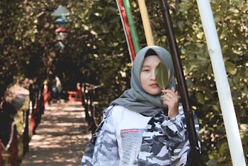 Photo of Woman Covering Her Left Eye With Green Leaf