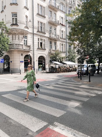 Photo of Woman Crossing Pedestrian Lane Near High-rise Building