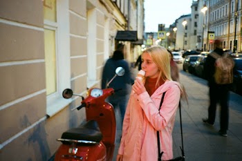 Photo of Woman Eating Ice Cream Near Red Motor Scooter by Side Walk