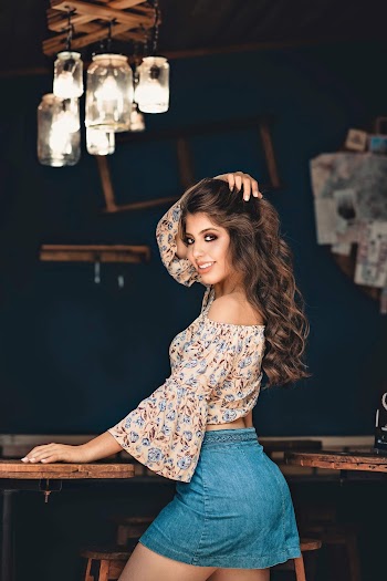 Photo of Woman Facing on Her Side While Posing by Wooden Table