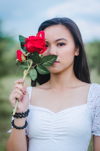 Photo of Woman Holding a Rose