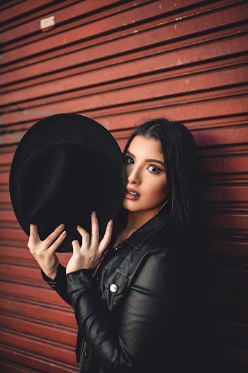 Photo of Woman Holding Black Hat