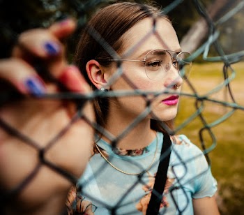 Photo Of Woman Holding Chain Link Fence