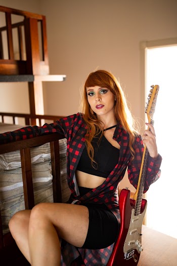 Photo of Woman Holding Electric Guitar