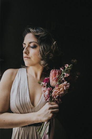 Photo of Woman Holding Flowers